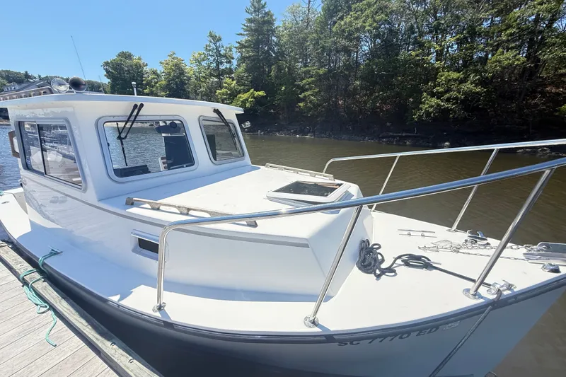 Slide: The Image of 2020 Seaway 24 boat docked on a sunny day, surrounded by trees. - 43
