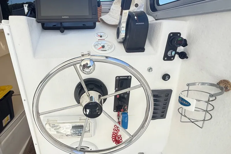 Slide: The Image of Helm of a 2020 Seaway 24 boat with steering wheel and control panel. - 13