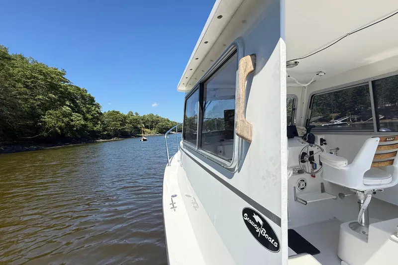 Slide: The Image of 2020 Seaway 24 boat cruising on a scenic river under a clear blue sky. - 27