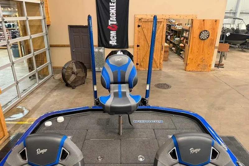 Slide: The Image of 2025 Ranger Z520R Cup-Equipped boat interior with blue and gray seating in a showroom. - 8
