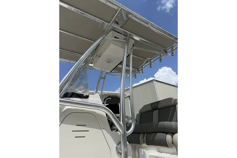 Slide: The Image of 2027 Key West 203 FS boat interior with T-top and seating, under a clear blue sky. - 3