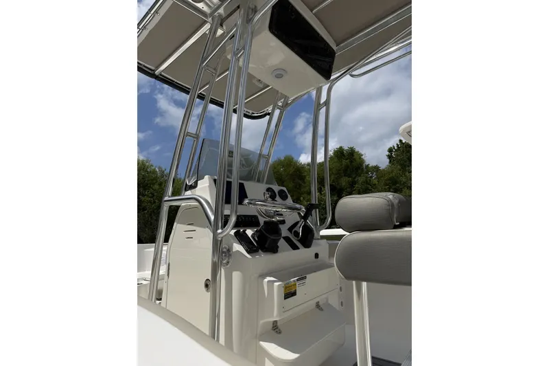 Slide: The Image of 2027 Key West 203 FS boat console with seating, stainless steel frame, and canopy under blue sky. - 4