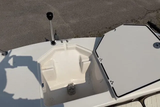 Slide: The Image of 2020 Carolina Skiff 19 LS boat storage compartment with open hatch and control lever. - 17