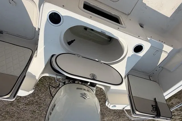 Slide: The Image of 2020 Carolina Skiff 19 LS boat interior with Suzuki outboard motor and storage compartments. - 13