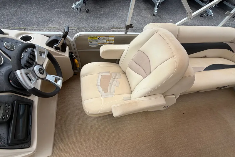 Slide: The Image of 2014 Godfrey SWEETWATER 2086 boat interior with steering wheel and beige seating. - 9