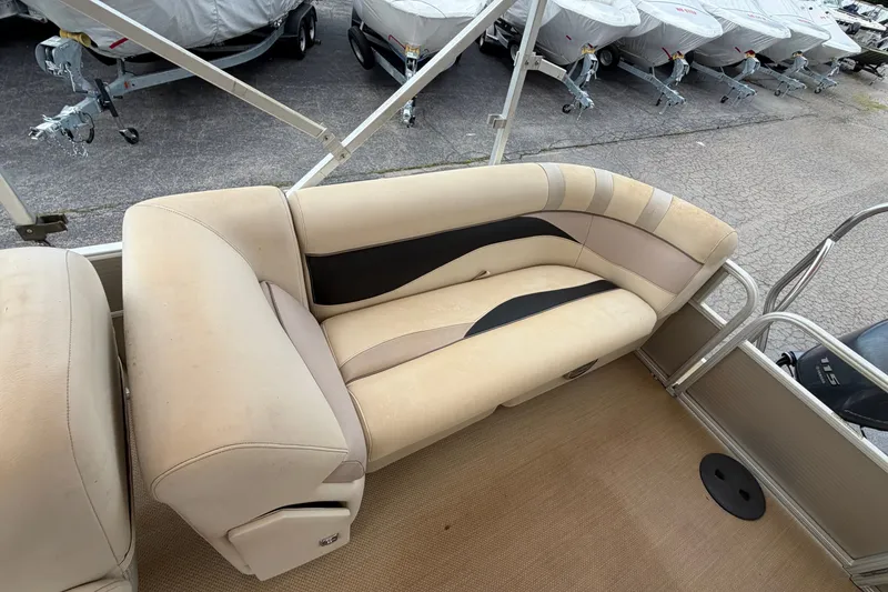 Slide: The Image of 2014 Godfrey SWEETWATER 2086 boat interior with beige seating and covered boats in background. - 6