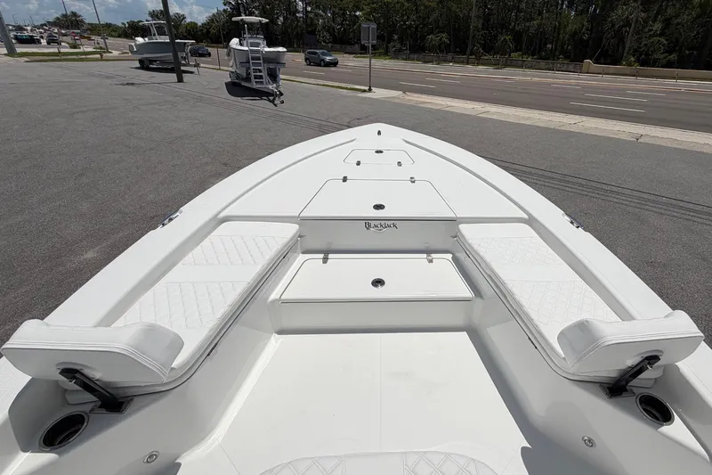 Slide: The Image of The image shows the deck of a 2026 BlackJack 224 boat with white upholstery. - 20