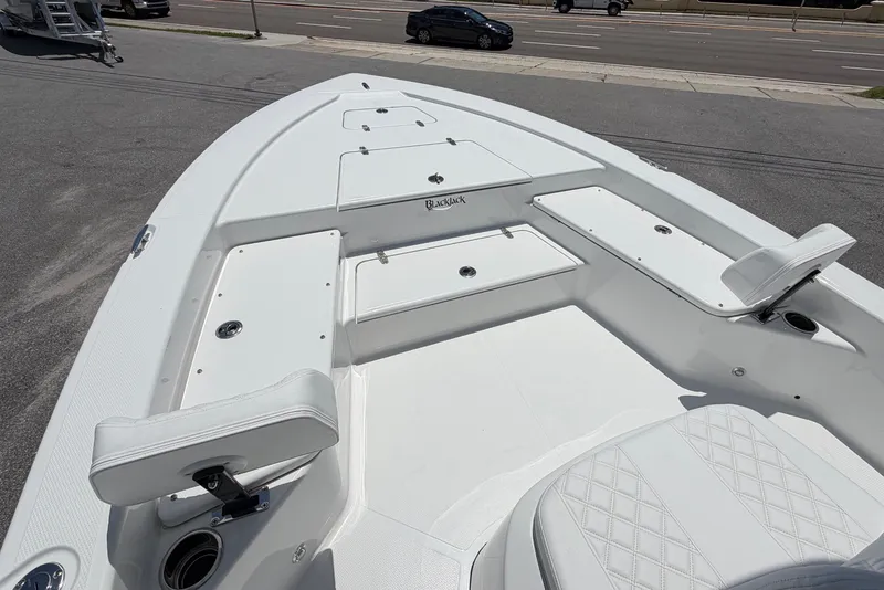 Slide: The Image of The image shows the deck of a 2026 BlackJack 224 boat with white upholstery. - 18