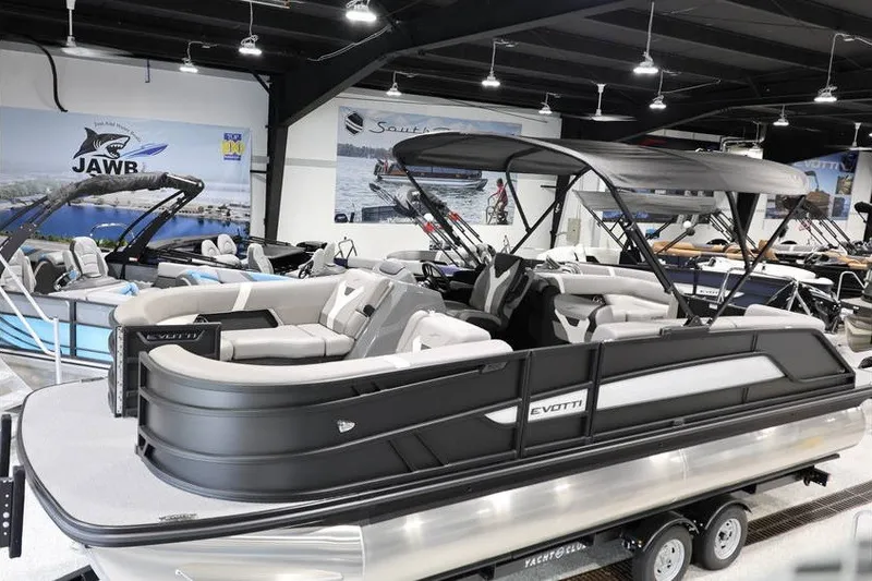 The Image of 2026 Evotti 523QL OMNI pontoon boat displayed in a showroom with other boats. - 1