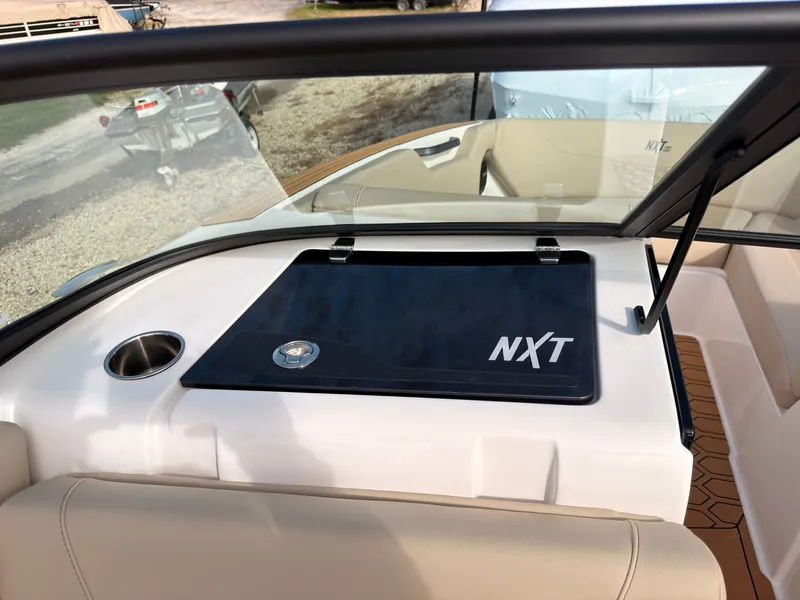 Slide: The Image of The image shows the cockpit of a MasterCraft NXT22 boat with a black cover compartment. - 39