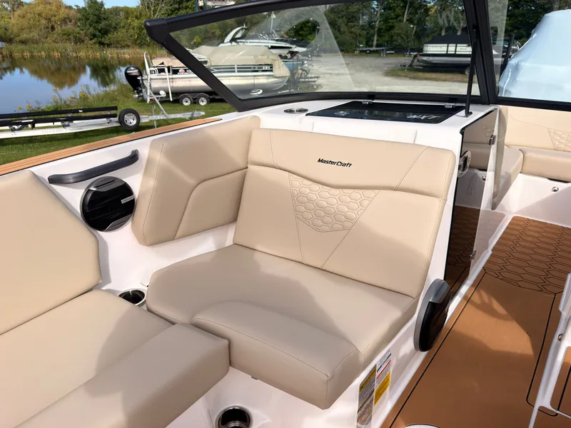 Slide: The Image of The image shows the interior of a MasterCraft NXT22 boat with beige seating and a clear sky. - 36