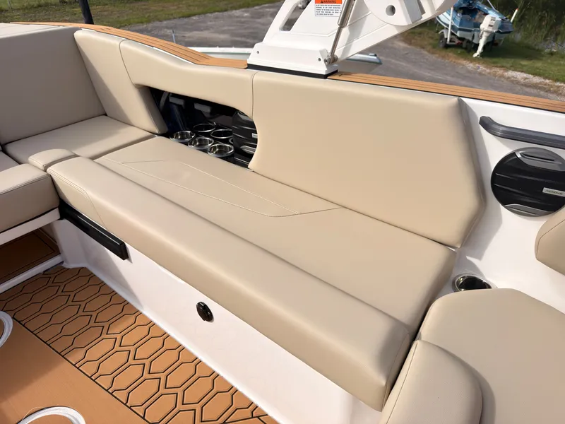 Slide: The Image of The image shows the beige seating of a 2027 MasterCraft NXT22 boat with cup holders. - 32