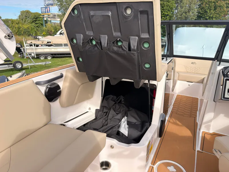 Slide: The Image of The image shows the interior of a MasterCraft NXT22 boat with beige seating and storage space. - 37