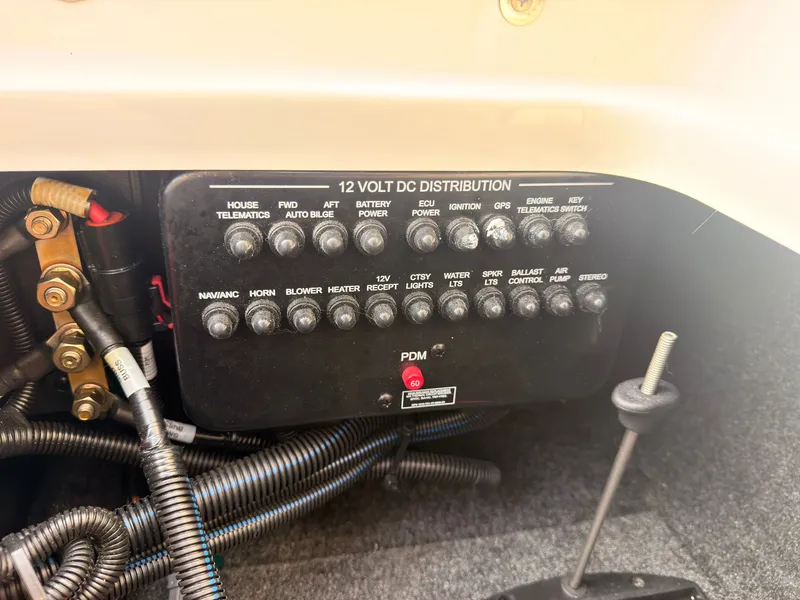Slide: The Image of A 12-volt DC distribution panel with various switches and wiring inside a boat. - 30