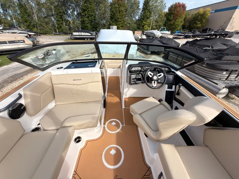 Slide: The Image of The image shows the cockpit of a 2027 MasterCraft NXT22 boat with beige seating. - 35