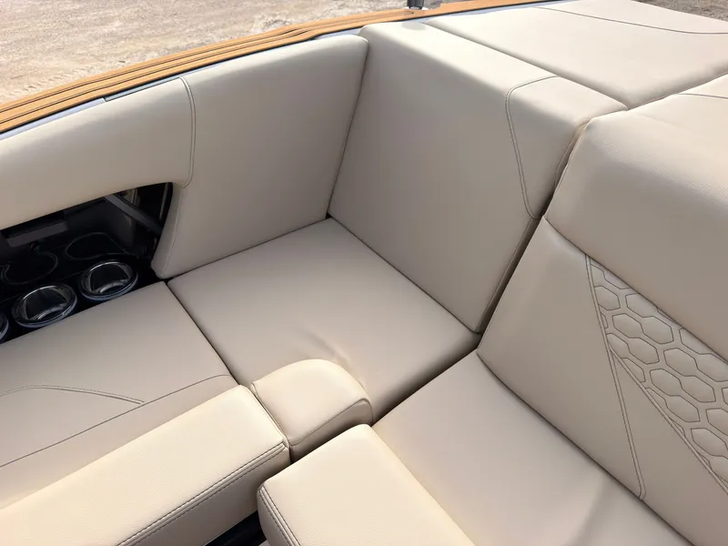 Slide: The Image of The 2027 MasterCraft NXT22 features luxurious cream upholstery with a honeycomb pattern and cup holders. - 23