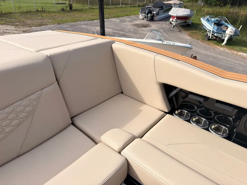 Slide: The Image of The image shows beige upholstery in the rear seating area of a MasterCraft NXT22 boat. - 28
