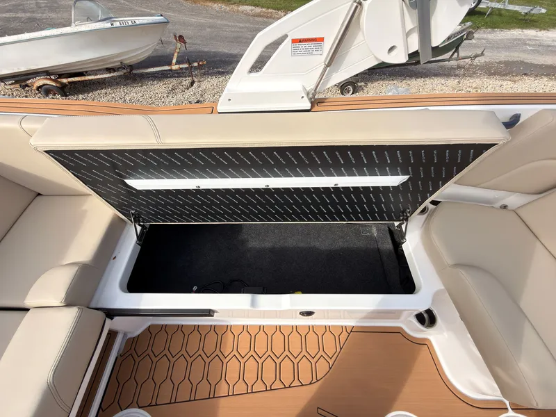Slide: The Image of The image shows the interior of a MasterCraft NXT22 boat with an open storage compartment. - 33