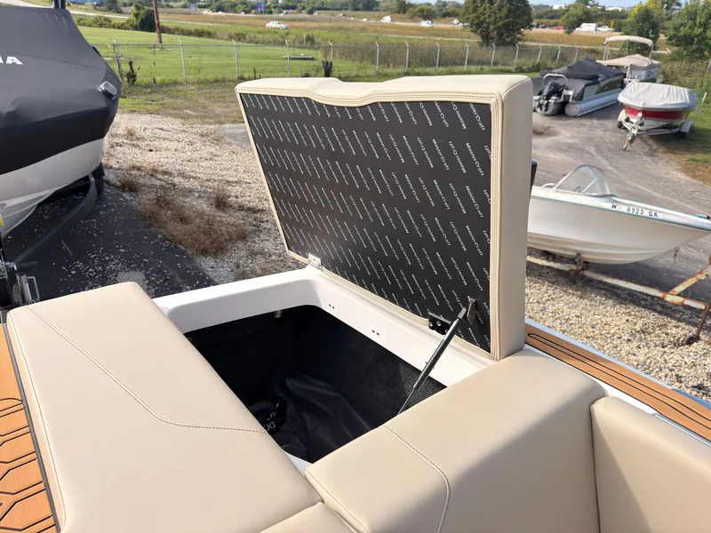 Slide: The Image of An open storage compartment at the rear of a MasterCraft NXT22 boat, surrounded by other boats. - 13