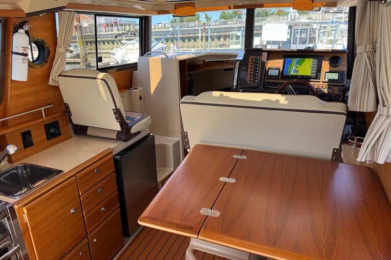 Slide: The Image of Interior of 2018 Ranger Tugs R-27 boat with wood finishes and navigation equipment. - 13