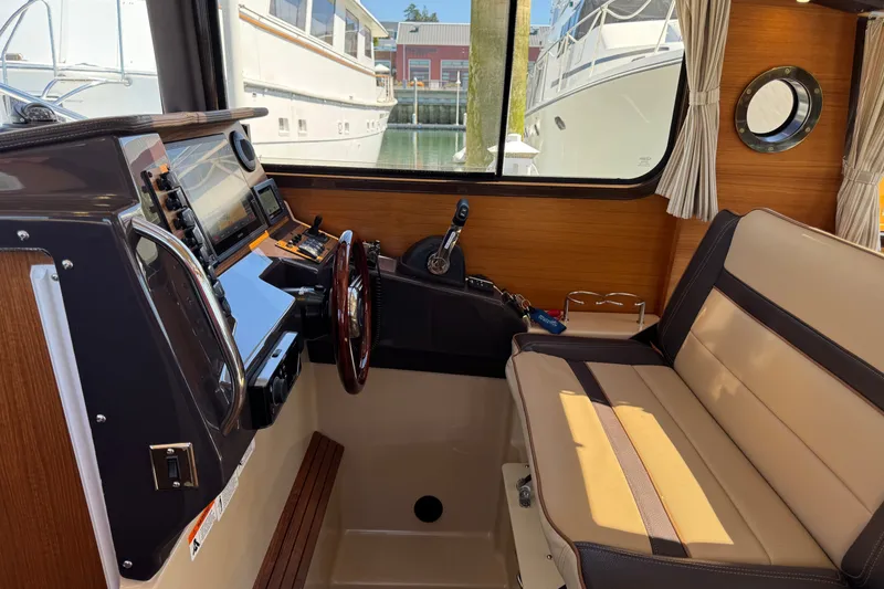 Slide: The Image of Interior of 2018 Ranger Tugs R-27 boat with helm and seating area. - 19