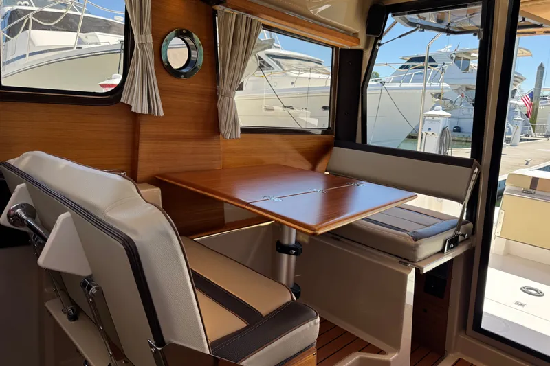 Slide: The Image of Interior of 2018 Ranger Tugs R-27 boat with wooden table and seating. - 23