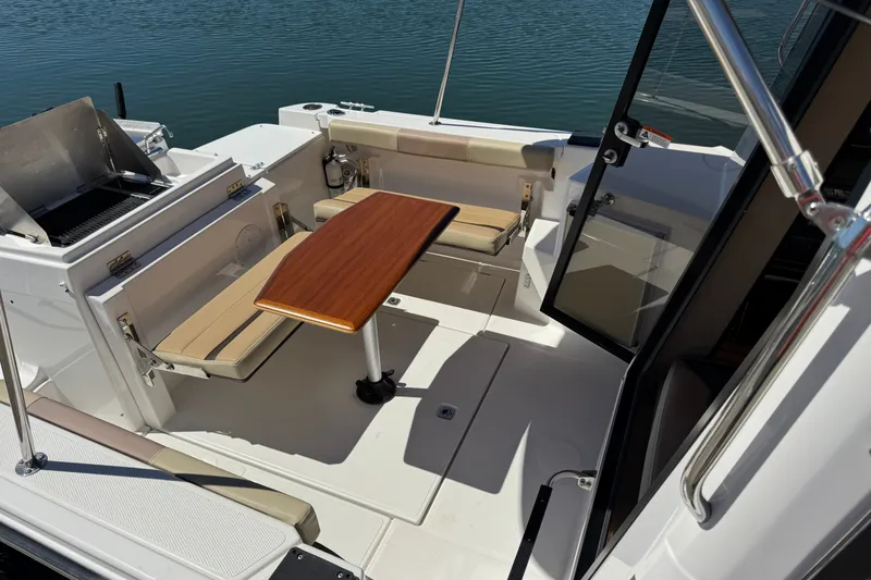 Slide: The Image of 2018 Ranger Tugs R-27 boat interior with seating, table, and grill by the water. - 5