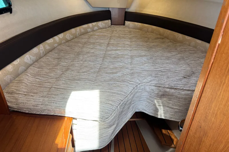 Slide: The Image of 2018 Ranger Tugs R-27 cabin interior with cozy bed and wooden accents. - 20