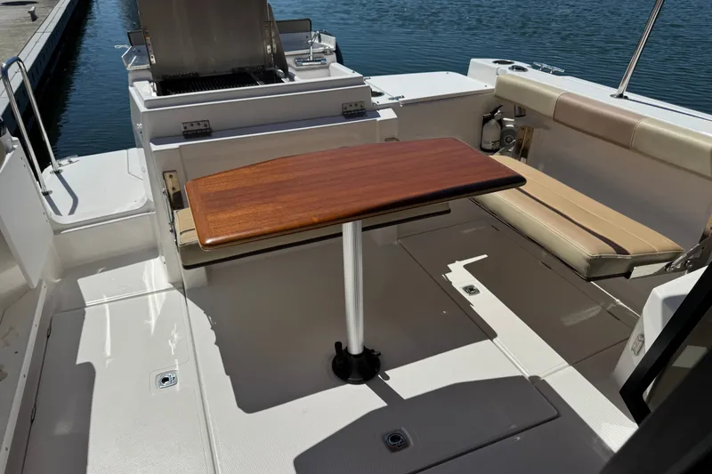 Slide: The Image of 2018 Ranger Tugs R-27 boat interior with wooden table and seating area. - 8