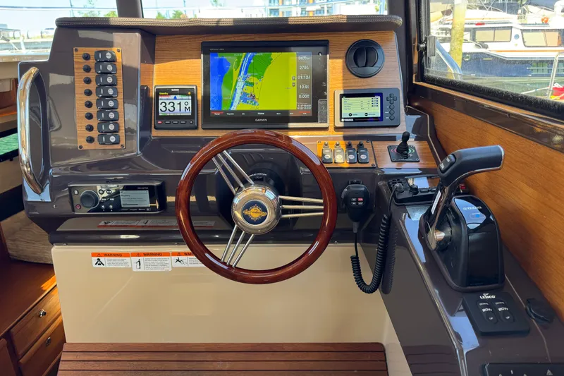 Slide: The Image of 2018 Ranger Tugs R-27 helm with navigation screens and controls. - 16