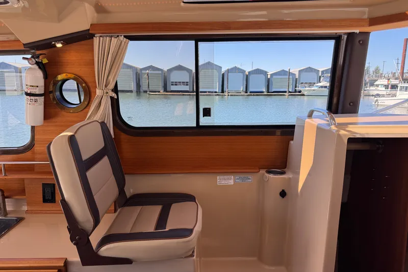 Slide: The Image of Interior view of 2018 Ranger Tugs R-27 boat with marina backdrop. - 18