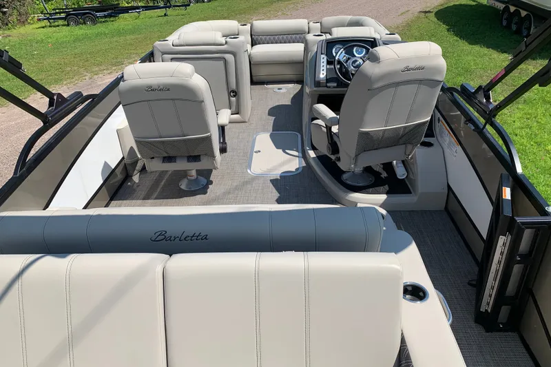 Slide: The Image of 2022 Barletta Lusso 23UC pontoon boat interior with plush seating and modern dashboard. - 7
