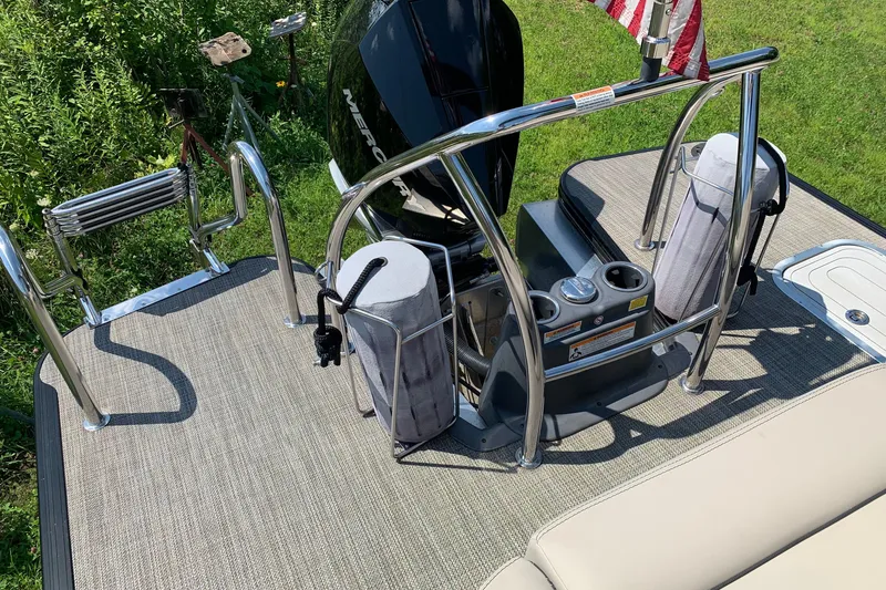 Slide: The Image of 2022 Barletta Lusso 23UC boat deck with motor, ladder, and American flag. - 9