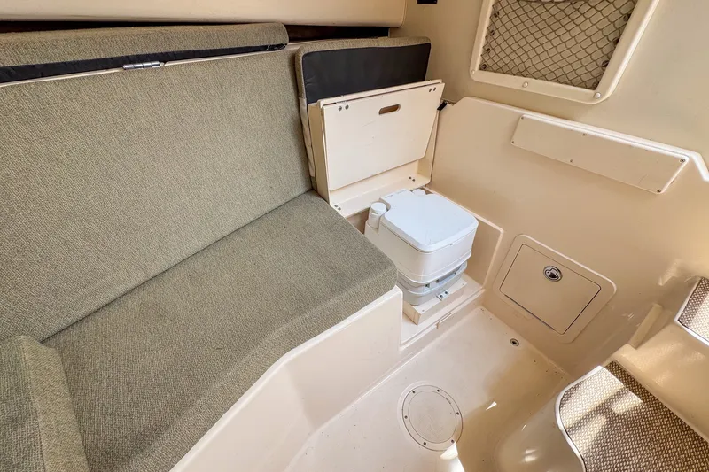Slide: The Image of 2013 Grady-White Gulfstream 232 cabin interior with seating and portable toilet. - 27