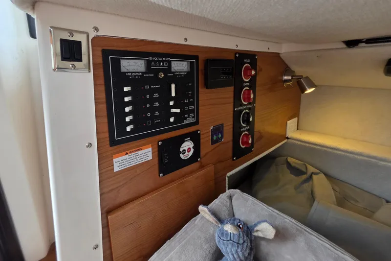 Slide: The Image of Control panel inside 2027 Cutwater C-248 Coupe boat cabin with plush toy. - 28