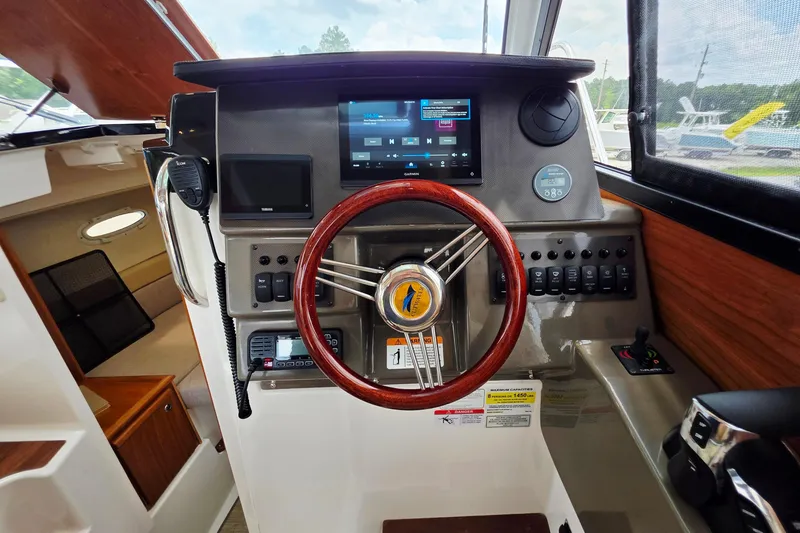 Slide: The Image of 2027 Cutwater C-248 Coupe helm with modern controls, wooden steering wheel, and navigation display. - 15