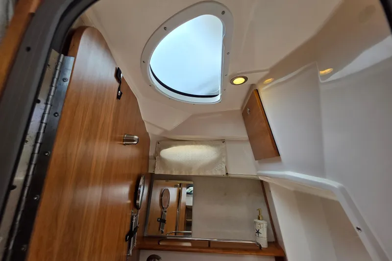 Slide: The Image of Interior of 2027 Cutwater C-248 Coupe boat, featuring wood accents and a skylight. - 21