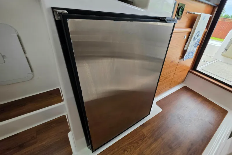 Slide: The Image of Interior of 2027 Cutwater C-248 Coupe featuring sleek stainless steel refrigerator. - 25
