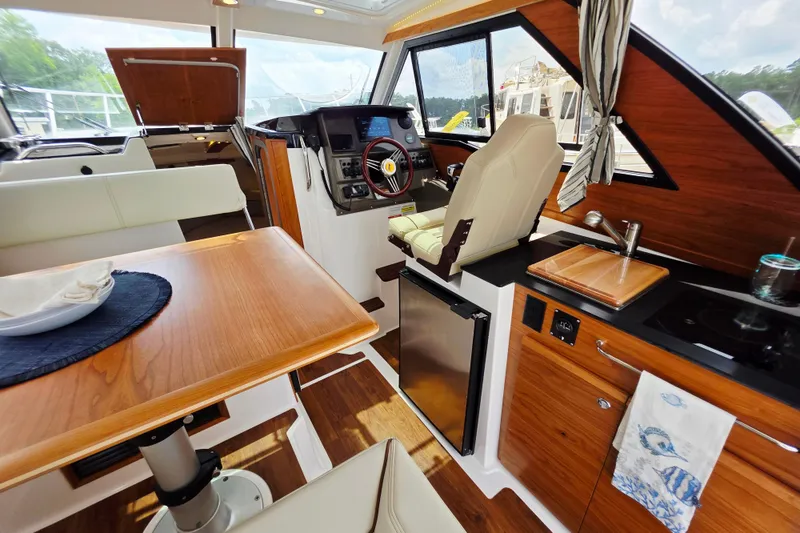Slide: The Image of Interior of 2027 Cutwater C-248 Coupe, featuring helm, kitchenette, and dining area. - 14