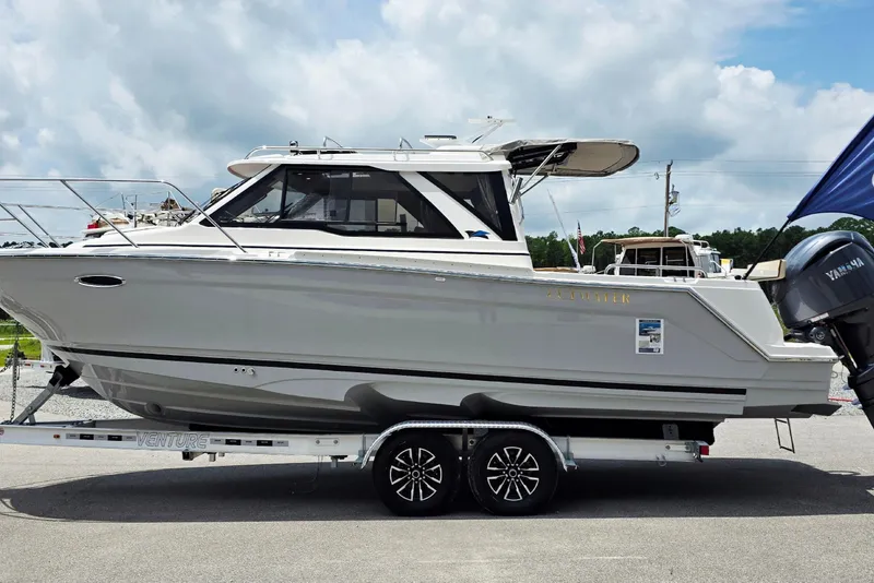 The Image of 2027 Cutwater C-248 Coupe boat on trailer, side view, under cloudy sky. - 1