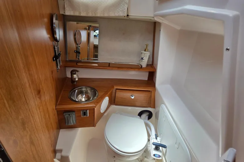 Slide: The Image of 2027 Cutwater C-248 Coupe bathroom with wooden cabinetry, stainless steel sink, and compact toilet. - 22