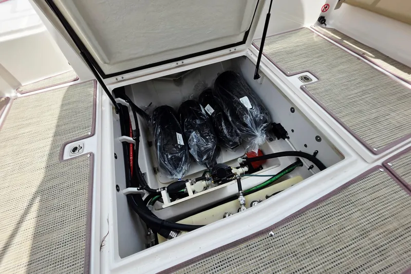 Slide: The Image of Open storage compartment in 2027 Cutwater C-248 Coupe boat, showing equipment and wiring. - 29