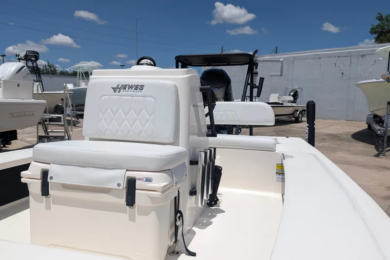 Slide: The Image of 2022 Hewes Redfisher 18 boat with white seating, displayed outdoors under a clear sky. - 22