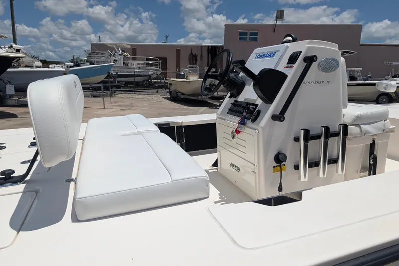 Slide: The Image of 2022 Hewes Redfisher 18 boat interior with steering console and seating under a sunny sky. - 26