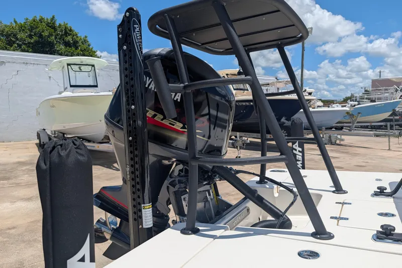 Slide: The Image of 2022 Hewes Redfisher 18 boat with Yamaha engine, docked under a clear blue sky. - 27