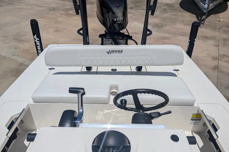 Slide: The Image of 2022 Hewes Redfisher 18 boat interior with steering wheel and seating. - 18