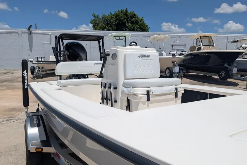 Slide: The Image of 2022 Hewes Redfisher 18 boat on trailer, displayed outdoors under blue sky. - 23