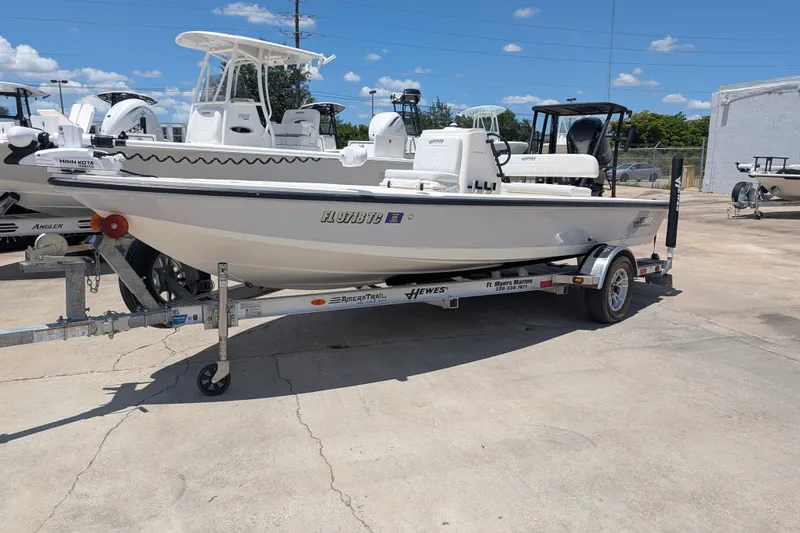 The Image of 2022 Hewes Redfisher 18 boat on trailer, parked outdoors under a clear blue sky. - 1