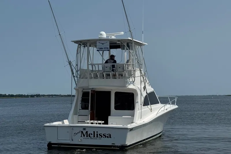 Slide: The Image of 2004 Luhrs 38 Convertible boat named "Melissa" cruising on open water. - 44