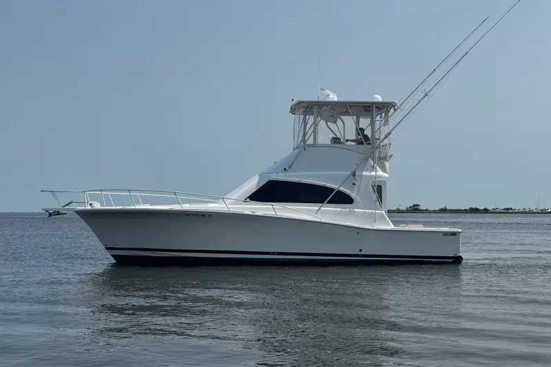 The Image of 2004 Luhrs 38 Convertible yacht on calm water, side view. - 0
